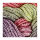 Close-up of several skeins of fuzzy yarn in mixed colors, including pink, light green, lavender, and gray-white, filling the frame.