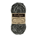 A skein of Scheepjes Stone Washed XL yarn with a black and white heathered texture, wrapped in a beige paper label.