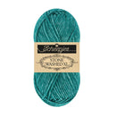 A skein of Scheepjes Stone Washed XL yarn in a teal color, featuring a beige paper label with black text, set against a plain white background.