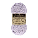 A skein of Scheepjes Stone Washed XL yarn in a light lavender purple color, featuring its original paper label wrapper, set against a plain white background.