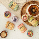 Colorful yarn balls with labels on a textured surface and woven basket.