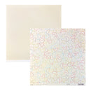 Two square sheets of paper shown on a white background: one plain warm cream sheet behind and one patterned sheet in front with a white base covered in thin multicolored abstract line drawings in red, blue, yellow, and brown.