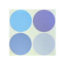 Four circular color swatches arranged on a 12x12 cardstock on a pale green square background, featuring light blue, medium blue, lavender purple, and very pale icy blue shades.