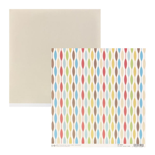 A sheet of patterned scrapbook paper with vertical rows of colorful oval motifs on a cream background, shown alongside a plain beige backing sheet on a white background.