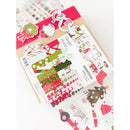 A sheet of Christmas-themed planner stickers displayed on top of a kraft paper envelope, with additional sticker sheets scattered around on a white background.
