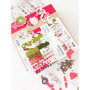 A sheet of Christmas-themed planner stickers displayed on top of a kraft paper envelope, with additional sticker sheets scattered around on a white background.