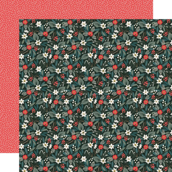 A sheet of patterned scrapbook paper with a dark teal botanical print featuring white flowers, green leaves, and red berries, layered over a solid coral red patterned sheet with white dots.