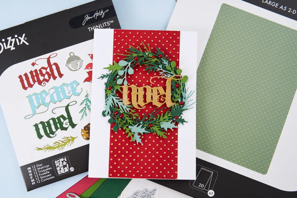A handmade Christmas greeting card featuring a green wreath with red berries and gold 'Merry' lettering over a red polka-dot background, displayed alongside its packaging and a green patterned paper sheet.