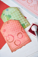 Decorative paper tags with a stamp and ink pad on a white surface