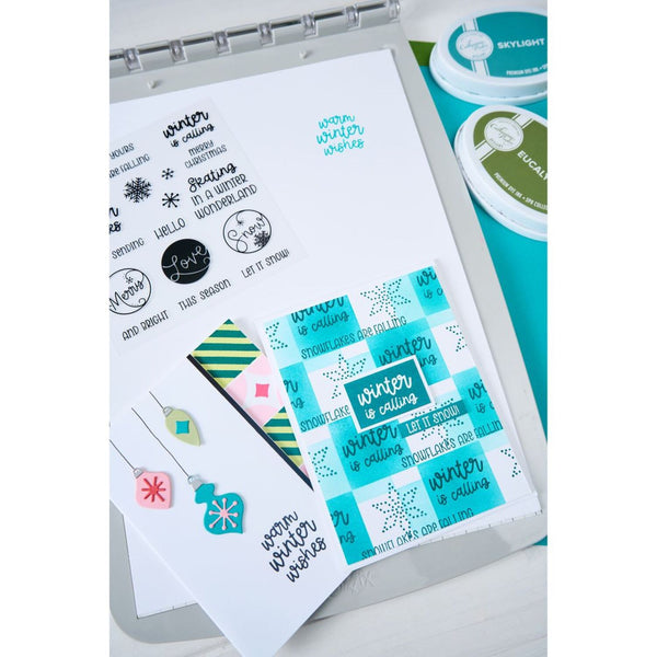 Collection of winter-themed stamps and dies on a white background