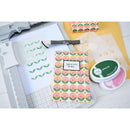 Crafting supplies including patterned paper, stamps, and a stamp pad on a white surface.