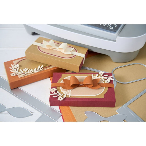 Card-making supplies including cut-out cards with bows and decorative elements on a white surface.