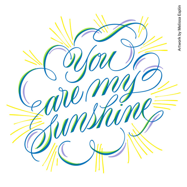Hand-lettered wall art reading 'You are my sunshine' in flowing blue, green, and purple script with yellow sunburst rays on a white background. Small vertical text at right reads 'Artwork by Melissa Esplin.
