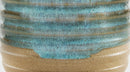 Close-up of a ceramic vessel showing a glossy turquoise-blue glazed upper section with horizontal ridges and a matte tan-brown unglazed lower section.