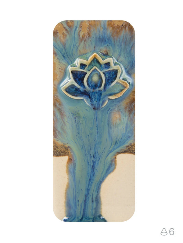 A rectangular ceramic tile with rounded corners, featuring a blue and gold lotus flower design on a textured background, shown against a plain white background.