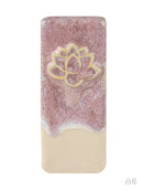 A rectangular ceramic tile or coaster with rounded corners, featuring a textured pink and white top half with a gold lotus flower design, and a smooth beige bottom half, shown on a plain white background.