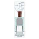 Wax seal stamp set in its retail packaging, featuring a wooden handle and two silver metal stamp frames, branded as 'Sealed by Spellbinder'.