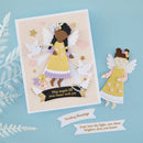 A handmade paper angel greeting card and matching cutout on a light blue background. The card features a layered angel figure in a yellow dress with white wings, surrounded by white doves, pink hearts, gold stars, and a black banner with blessings.