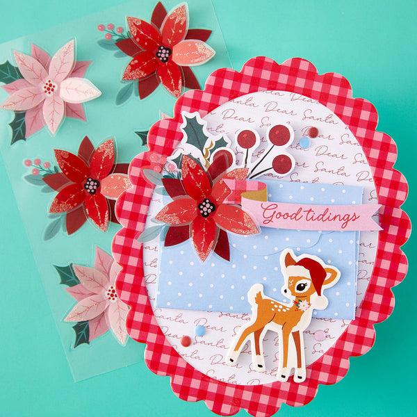 Christmas-themed card with reindeer, flowers, and 'Good tidings' text on a turquoise background.