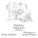 A black and white line art illustration of a sleeping cat under a blanket, with Christmas stockings hanging from bare tree branches and a small candle on a side table. Handwritten text below reads, 'May all your holiday dreams come true! Wishing you a dreamy Christmas.
