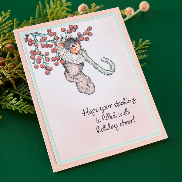 Christmas card with a mouse and candy cane design, surrounded by greenery.