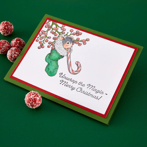 Christmas card with a mouse in a stocking and berries on a green background