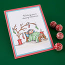 Christmas card with a cartoon bear in bed and decorative red balls on a green background