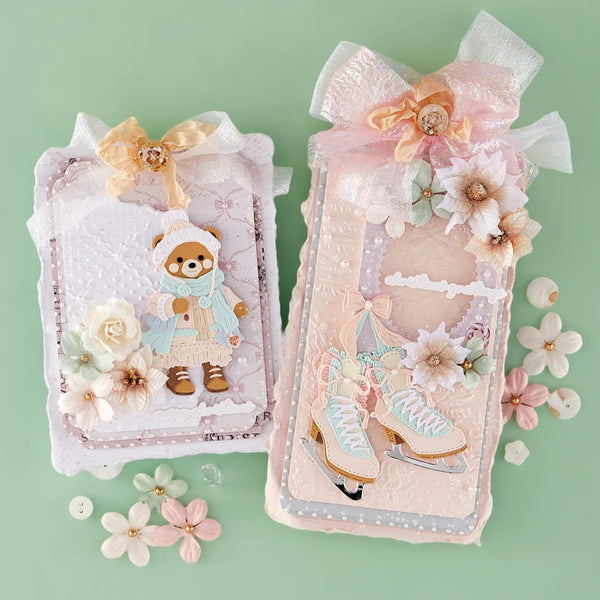 Two decorative handmade card or album cover designs displayed on a mint green background. The left design features a teddy bear in winter clothing with white and pale pink embellishments, and the right design shows ice skates with pale pink, white, and light blue embellishments.
