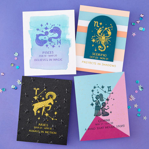 Four zodiac-themed greeting cards on a purple background with decorative elements.