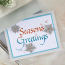 Season's Greetings card with decorative snowflakes on a marble surface