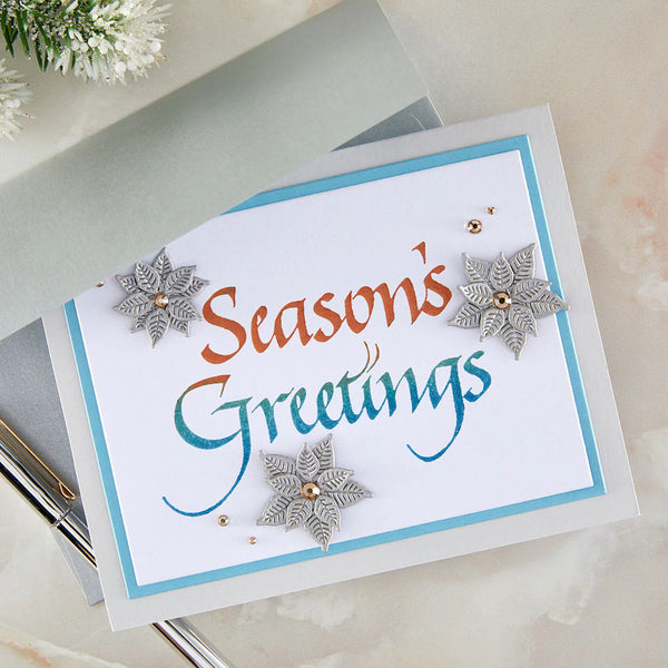 Season's Greetings card with decorative snowflakes on a marble surface