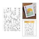 Clearing kit contents shown on a white background: a sheet of black line-art stamp designs, a sample card featuring a dog illustration, and another sheet/package labeled Around the Stormy Sea with more line-art motifs.