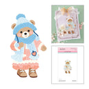 A craft kit featuring a cute teddy bear character in a winter outfit, shown as a large illustration on the left and as a packaged cutting dies sheet on the right. The right side also shows a decorated card embellished with the same teddy bear design.