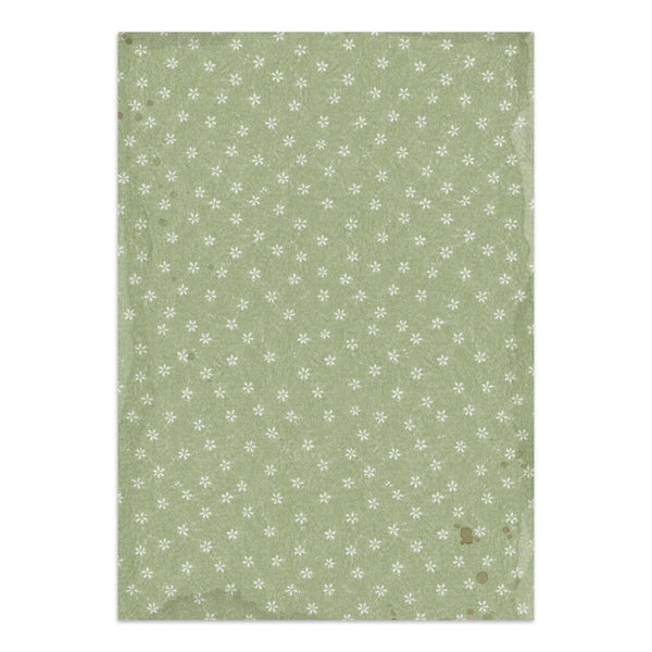 A rectangular sheet of textured paper with a vintage design, featuring a sage green background patterned with small white snowflakes and distressed edges.