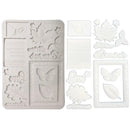 White embossed paper or cardstock embellishment sheet set featuring leaf, butterfly, envelope, and decorative text motifs on a plain white background.