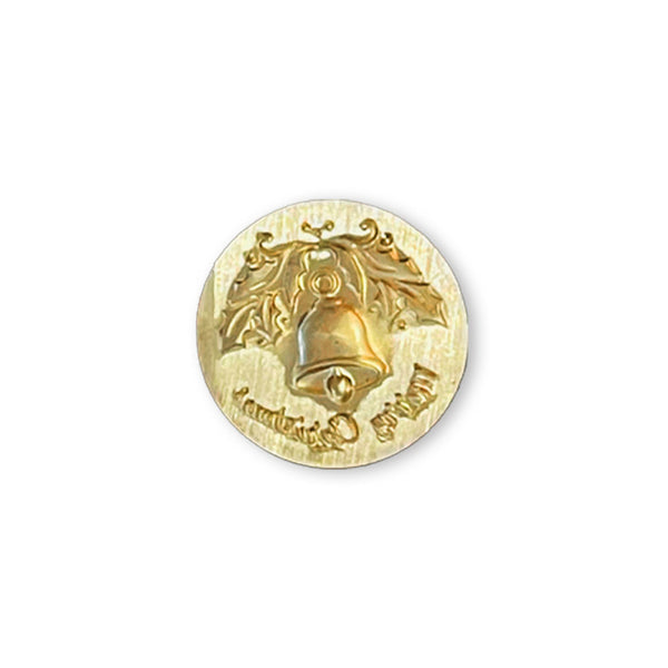 A round gold-toned button featuring a raised Christmas bell design with stylized ornaments and the words 'Merry Christmas' in an engraved script, shown on a plain white background.
