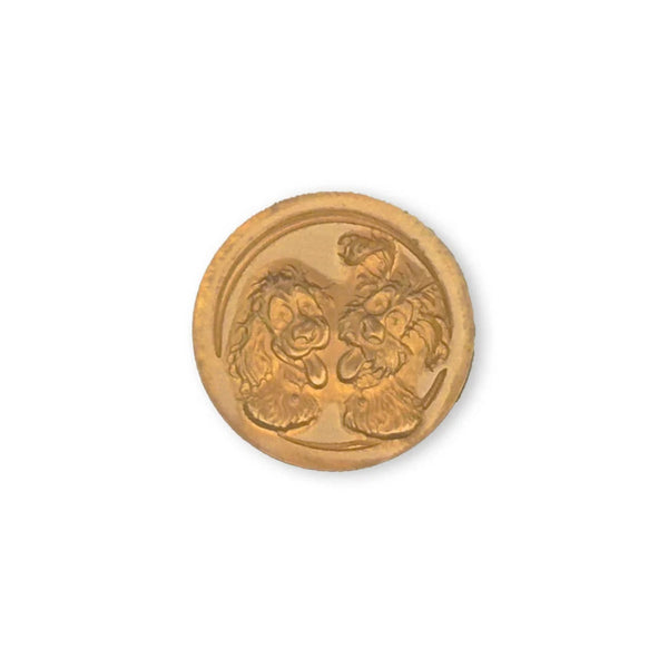 A round gold-colored button featuring an embossed design of two lions facing each other, set against a plain white background.