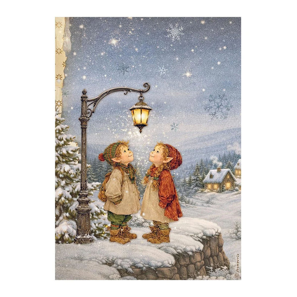 A vintage-style winter illustration showing two children standing on a snowy stone wall beneath a glowing streetlamp, looking up at snowflakes in a starry night sky. Snow-covered trees and small houses appear in the background.