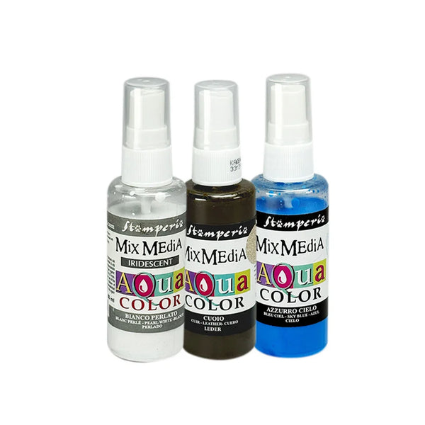 Three small spray bottles of Stampers Mix Media Aqua Color ink on a plain white background. The bottles contain clear, dark brown, and blue liquids, with white caps and colorful labels.