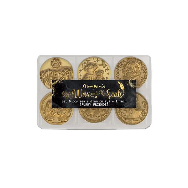 A set of six wax seals from Stamperia Wax & Seals, displayed in a clear plastic clamshell package with a black label. The wax seals are gold-toned and feature various classical emblems, including the word 'VERGAS' and a crowned figure.
