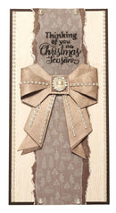Card with decorative bow and text 'Thinking of you this Christmas Season' on a textured background