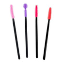 Four black cosmetic spoolie brushes with colorful bristles in pink, purple, magenta, and red, arranged vertically on a plain white background.