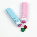 Two handheld rotary tools in pastel blue and pink, shown on a plain white background with three interchangeable circular heads in pink, red, and green.
