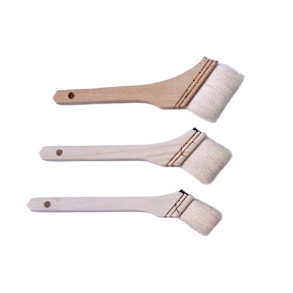 Three small angled paint brushes with light natural wood handles and off-white bristles, arranged vertically on a plain white background.