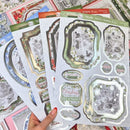 A hand with red manicured nails holds a fan of decorative Christmas-themed sticker sheets. The sheets feature vintage-style frames, snowman and winter illustrations, and phrases like 'Christmas Special' and 'Make the most of Christmas.
