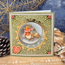 A square handmade greeting card featuring a detailed illustration of a robin bird wearing a red and cream scarf, set against a winter wreath design. The card is styled with a pinecone, dried botanicals, and a blue textured background.