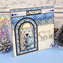 A handmade Christmas greeting card featuring a stained-glass-style polar bear illustration and the words 'Let it Snow' in gold foil, styled with pinecones and a small tree on a blue surface.