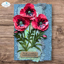 A handmade 3D poppy card featuring three layered red poppy flowers with dark centers, green textured stems and leaves, and a decorative blue embossed background with a quote on a wooden surface.