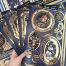 A hand holds several decorative sticker sheets featuring festive Christmas and New Year designs, including a robin, deer, snowman, snowflake, and ornate gold frames on a dark navy background. The sheets are labeled 'Festive Occasions' and 'Merry & Happy Handstamped'.