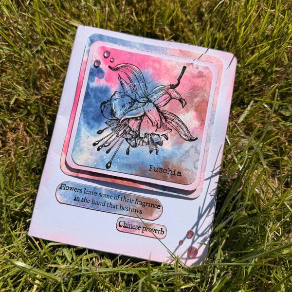 Card with floral design and text on grass